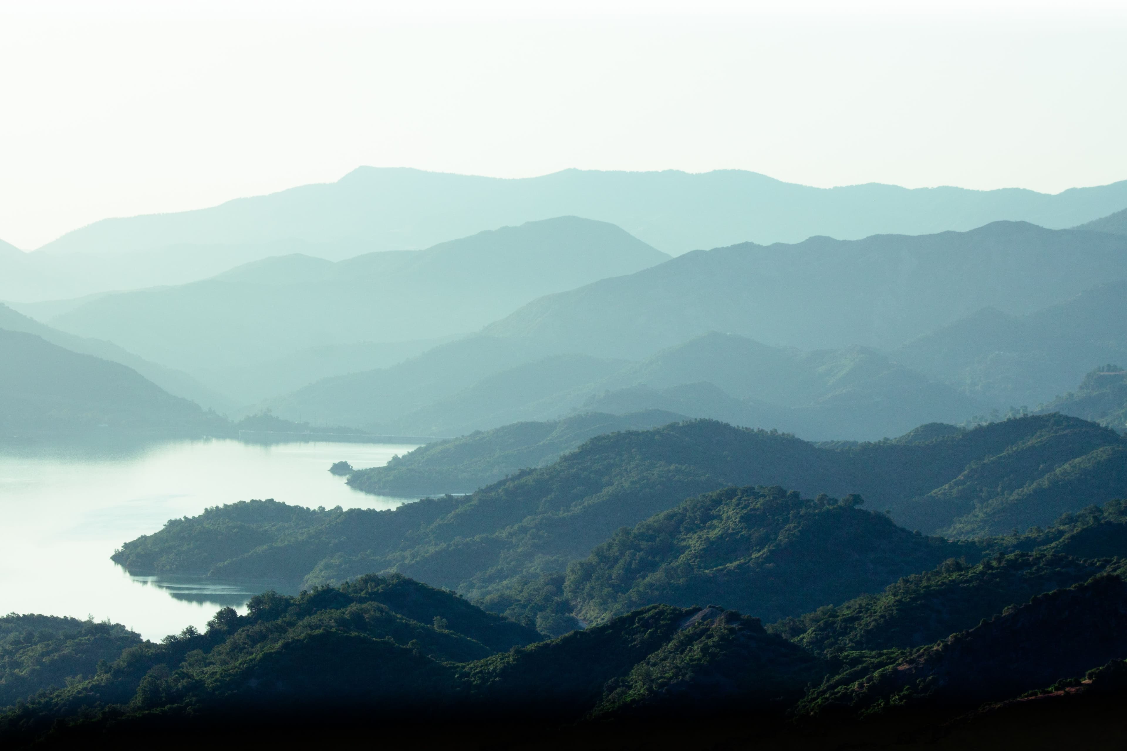 Layered mountain ridges fading into morning mist